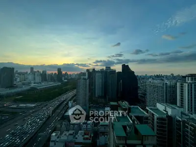 Stunning cityscape view from high-rise building at sunset, showcasing urban skyline and vibrant sky.