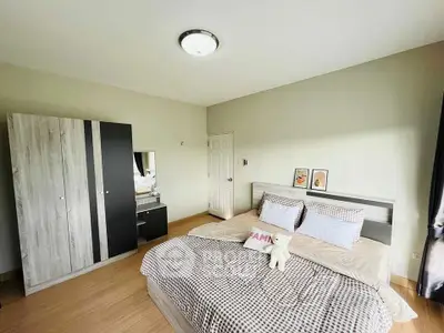 Spacious bedroom with modern decor and ample natural light, featuring a stylish wardrobe and cozy bedding.