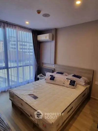 Modern bedroom with large window and air conditioning in urban apartment