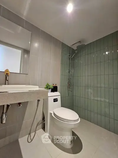 Modern bathroom with sleek design, featuring a shower and contemporary fixtures.