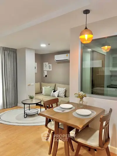 Modern living room with dining area, featuring stylish furniture and warm lighting in a cozy apartment.