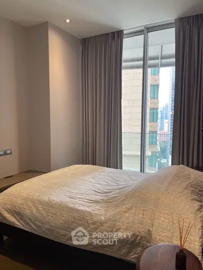 Modern bedroom with large window and city view in luxury apartment