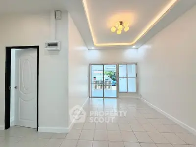 Spacious living room with modern lighting and large windows for natural light.