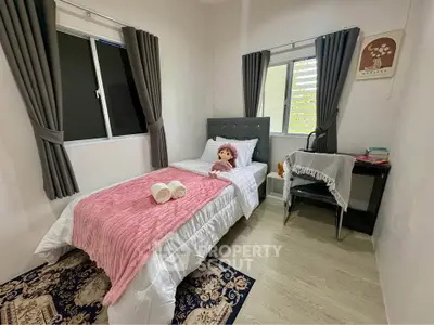 Cozy bedroom with twin bed, plush decor, and natural light from two windows, perfect for restful nights.