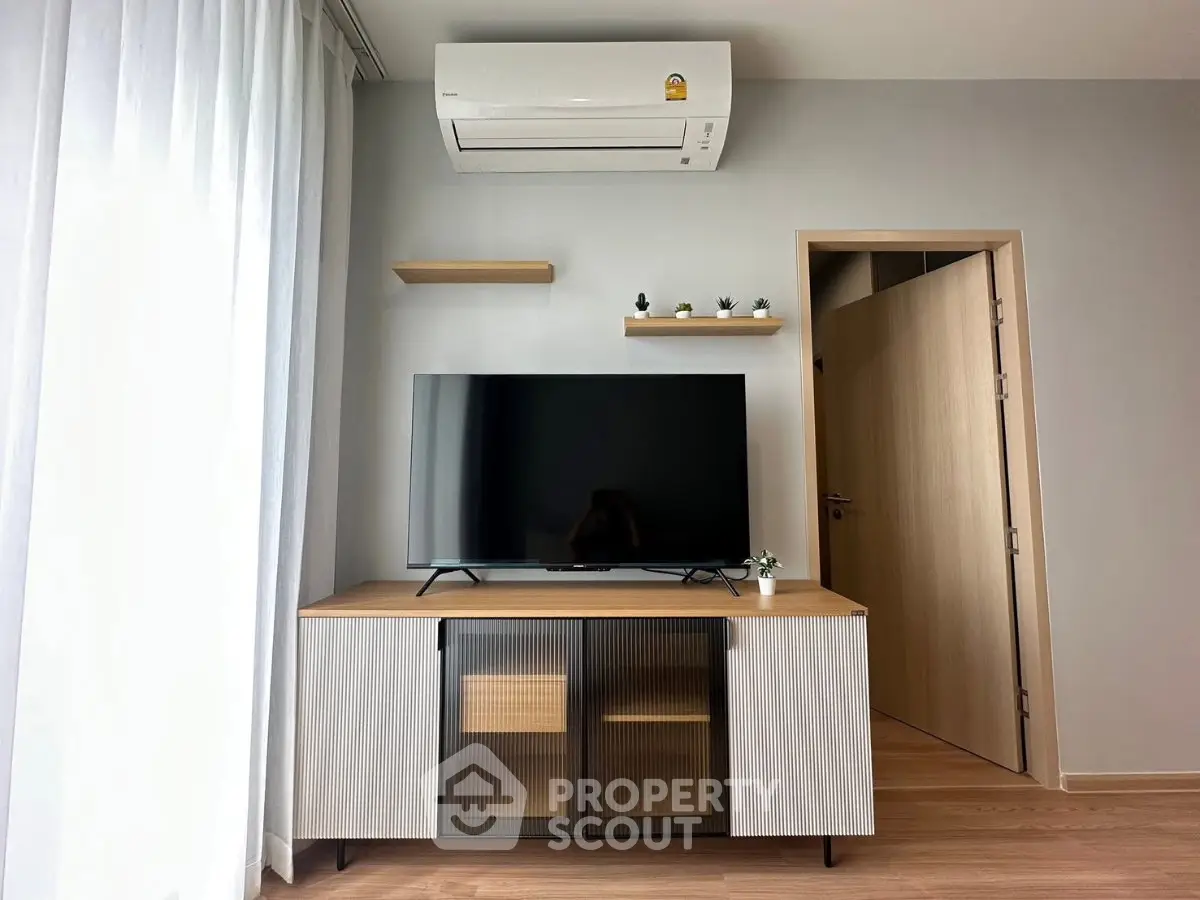 Modern living room with sleek TV stand, air conditioning, and stylish decor