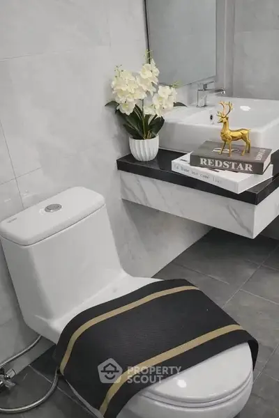 Modern bathroom with elegant decor and sleek fixtures, featuring a stylish toilet and vanity.