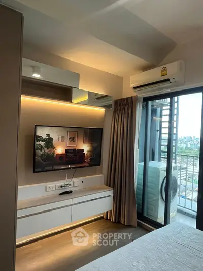 Modern bedroom with balcony view, featuring sleek built-in TV unit and air conditioning.