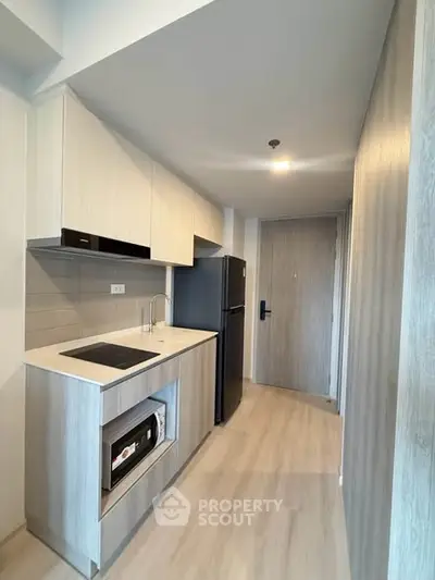 Modern kitchen with sleek cabinetry and built-in appliances in a compact layout.
