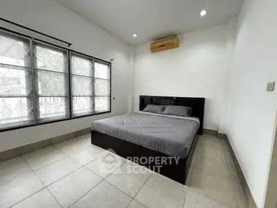 Spacious bedroom with large windows and modern furnishings