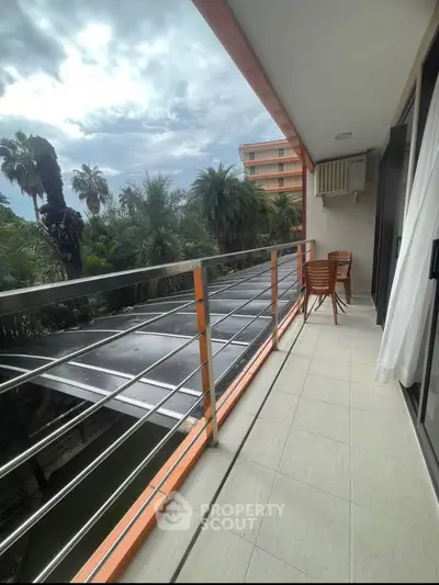 Spacious balcony with scenic view of lush greenery and modern outdoor seating.