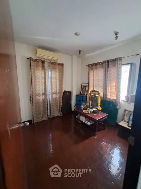 Cozy room with wooden flooring and natural light, ideal for a study or small living space.