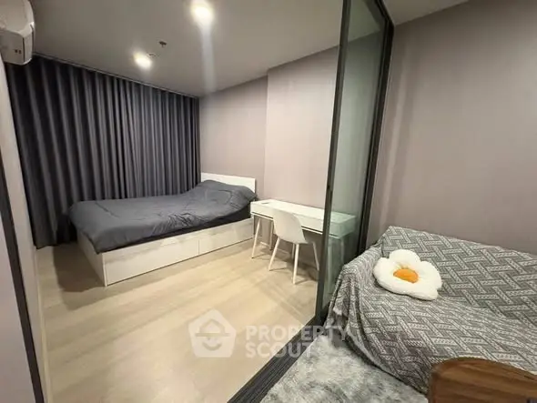 Modern bedroom with cozy decor and glass partition in stylish apartment.