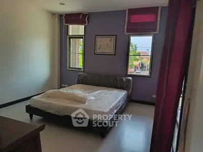 Spacious bedroom with large windows and modern decor in a stylish home.
