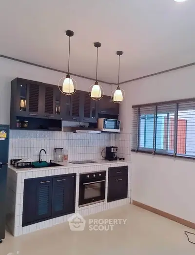 Modern kitchen with sleek cabinetry and pendant lighting
