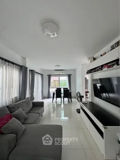 Spacious modern living room with sleek furniture and large windows for natural light.