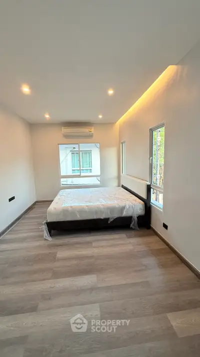 Spacious bedroom with modern design and large windows for natural light.