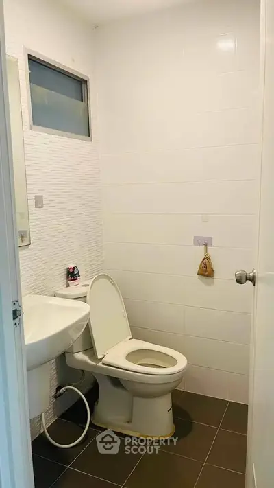 Modern bathroom with white tiles and sleek fixtures in a real estate property.