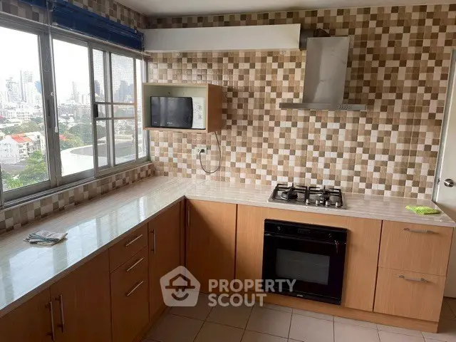 Modern kitchen with city view, featuring gas stove and built-in oven, ideal for culinary enthusiasts.