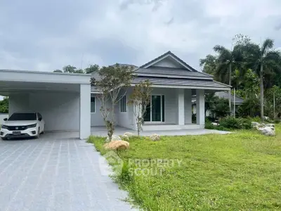 Charming single-story home with spacious driveway and lush green lawn, perfect for family living.
