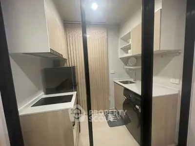 Modern kitchen with sleek cabinetry and built-in appliances in a compact layout.
