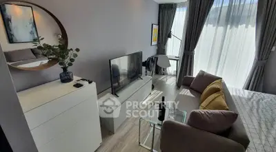 Modern living room with stylish decor, featuring a cozy sofa, large TV, and elegant curtains.