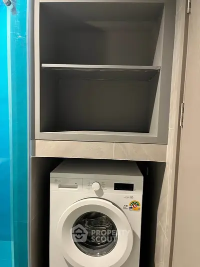Compact laundry area with modern washing machine and storage shelves in a stylish bathroom.