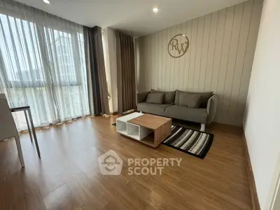 Modern living room with stylish decor and large windows offering natural light.