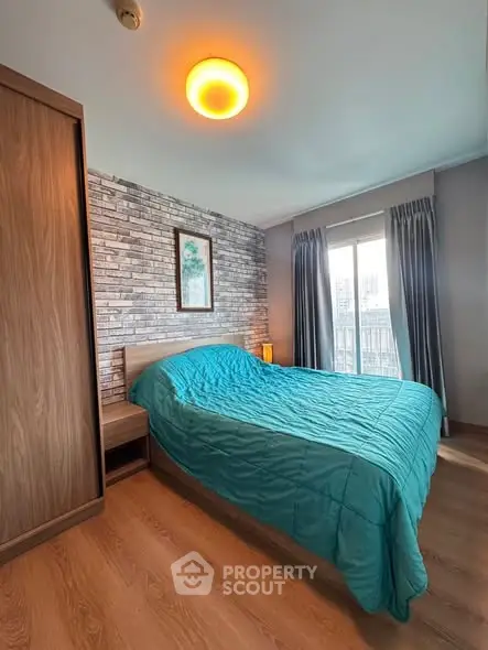 Cozy bedroom with modern decor and large window offering natural light and city views.