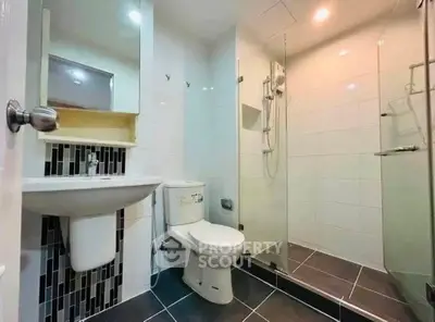 Modern bathroom with sleek design, featuring a glass shower enclosure and contemporary fixtures.