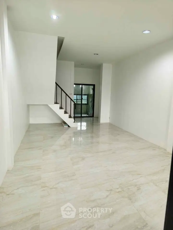 Spacious modern living room with elegant staircase and glossy tiled flooring