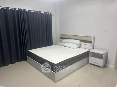 Spacious bedroom with modern bed and sleek curtains, perfect for restful nights.