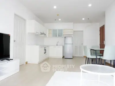 Modern open-plan living room with kitchen, dining area, and sleek appliances.
