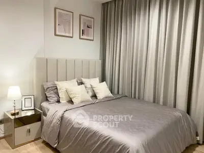 Elegant bedroom with modern decor and cozy ambiance, featuring plush bedding and stylish artwork.