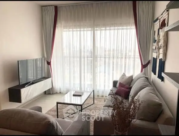 Cozy living room with modern decor and large window view.