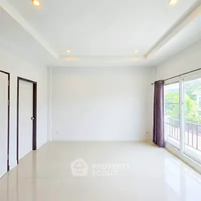 Spacious and bright empty room with large windows and balcony access, perfect for customization.