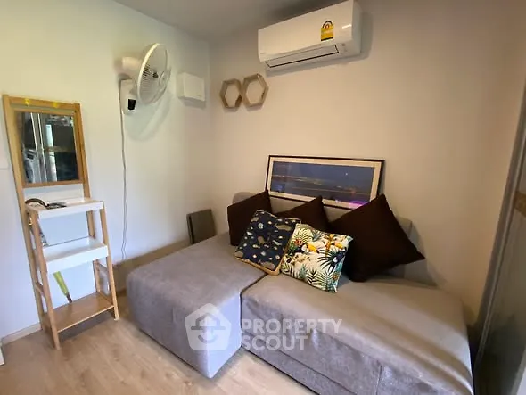 Cozy living room with modern sofa and air conditioning unit, perfect for relaxation.