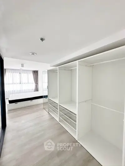 Spacious bedroom with built-in wardrobe and large windows for natural light.