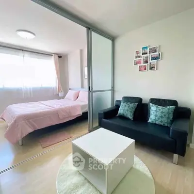 Cozy bedroom with sliding glass partition and stylish living area.