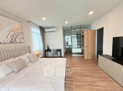 Spacious modern bedroom with elegant decor and ensuite bathroom, featuring a sleek design and ample natural light.