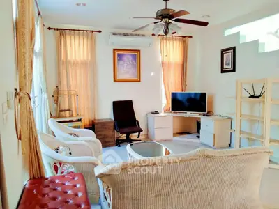 Charming living room with cozy seating and natural light, perfect for relaxation and entertainment.