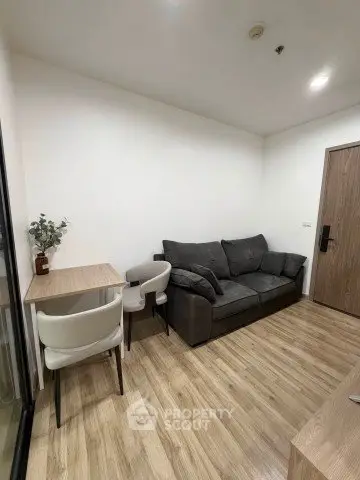 Cozy living room with modern sofa and dining table, perfect for small apartments.