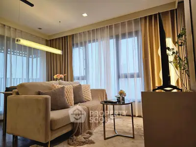 Elegant living room with cozy sofa, stylish decor, and large windows with sheer curtains.