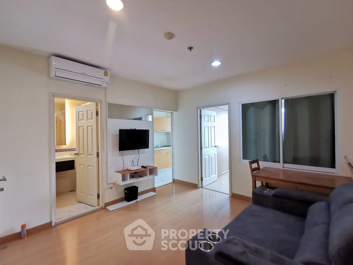 Spacious living room with modern furnishings and open kitchen layout in a cozy apartment.