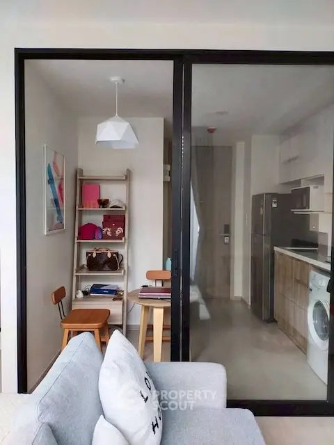 Modern apartment interior with kitchen and cozy living area, featuring stylish decor and appliances.