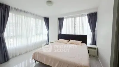 Bright and airy bedroom with large windows and elegant curtains