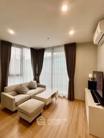 Modern living room with cozy sofa and large windows in a stylish apartment.