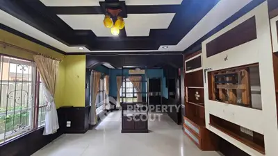 Spacious living room with elegant ceiling design and large windows for natural light.