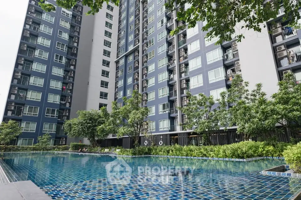 Modern high-rise building with a luxurious swimming pool and lush greenery.