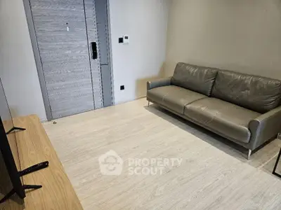 Modern minimalist living room with sleek wooden flooring and a comfortable leather sofa, perfect for urban living.