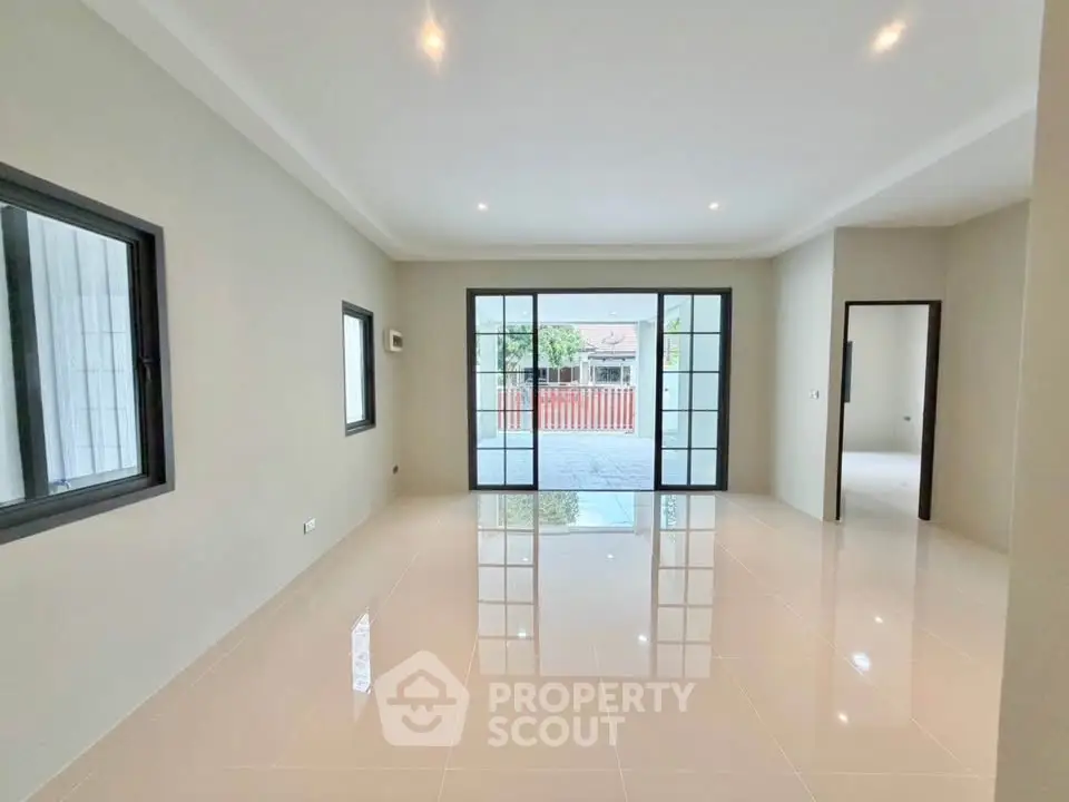 Spacious modern living room with large windows and glossy tile flooring